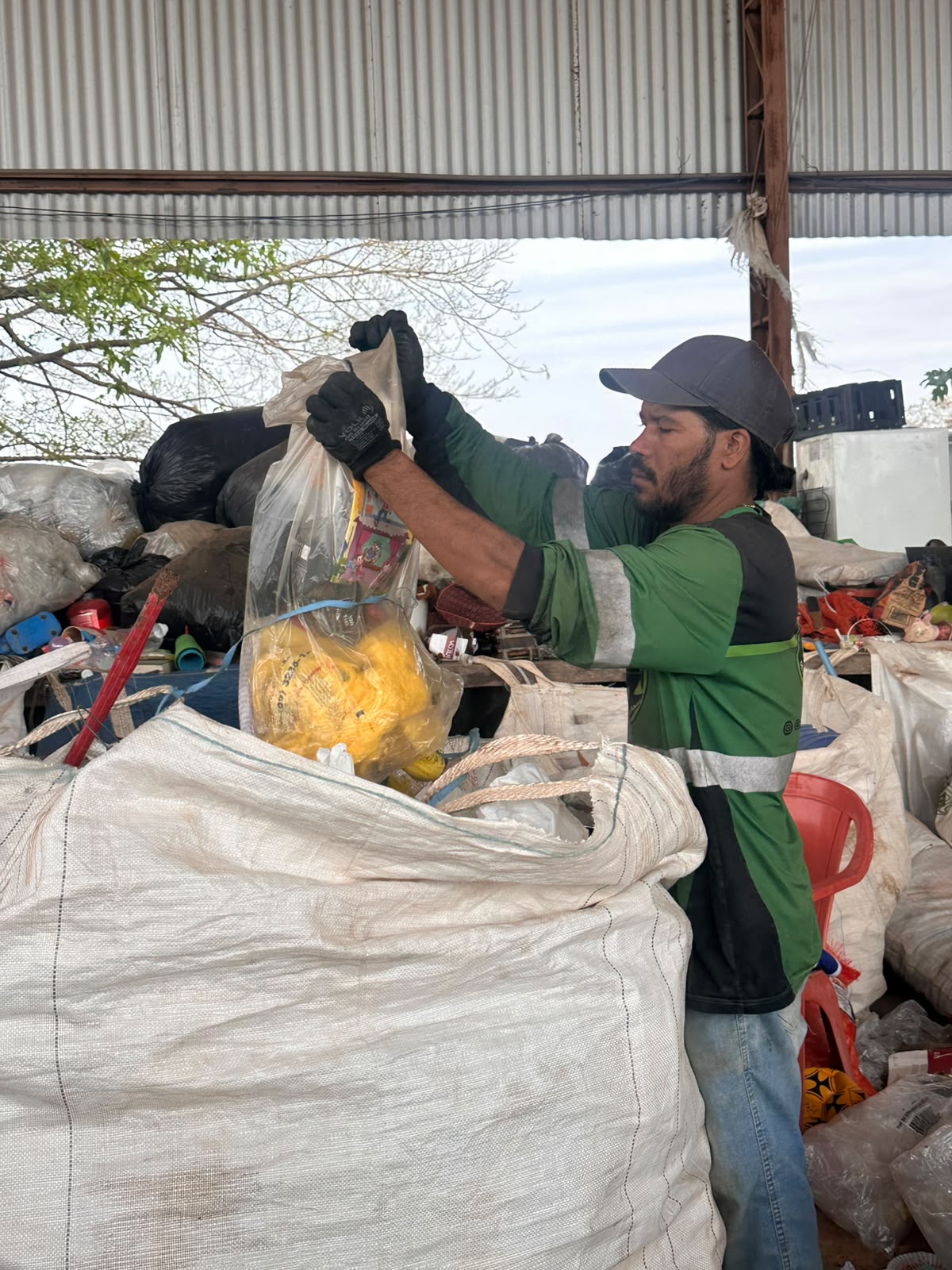 Colaborador da Vanzzella separando embalagens recicláveis em um bag